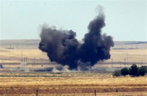 In this photo taken from the Turkish side of the border between Turkey and Syria, in Akcakale, Sanliurfa province, southeastern Turkey, smoke from a US-led airstrike rises over the outskirts of Tal Abyad, Syria, Sunday, June 14, 2015. Syrian Kurdish fighters closed in on the outskirts of a strategic Islamic State-held town on the Turkish border Sunday, Kurdish officials and an activist group said, potentially cutting off a key supply line for the extremists' nearby de facto capital. Taking Tal Abyad, some 80 kilometers (50 miles) from the Islamic State stronghold of Raqqa, would mean the group wouldn't have a direct route to bring in new foreign militants or supplies.(AP Photo/Lefteris Pitarakis)