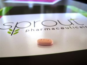 FILE - In this Friday, Sept. 27, 2013, file photo, a tablet of flibanserin sits on a brochure for Sprout Pharmaceuticals in the company's Raleigh, N.C., headquarters. Government health experts on Thursday, June 4, 2015 backed the approval of the experimental drug intended to boost the female sex drive, but stress that it should carry safety restrictions to manage side effects including fatigue, low blood pressure and fainting. (AP Photo/Allen G. Breed, File)