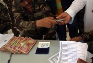 In this Wednesday, June 17, 2015 photo, Sunni tribal leaders receive their salaries in Habaniyah, 80 kilometers (50 miles) west of Baghdad, Iraq. A month after the fall of Ramadi, the Shiite-dominated Iraqi government is working to train and equip Sunni tribesmen from Anbar to fight the Islamic State group. In doing so, they must first repair a breach of trust that emerged from 18 months of neglect, which tribesmen say is the primary reason Ramadi fell into IS control. (AP Photo/ Khalid Mohammed)