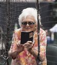 FILE- In this May 3, 2015, file photo, former first lady Barbara Bush takes photos with her cell phone before the Seattle Mariners take on the Houston Astros in a baseball game in Houston, Texas. Bush is promoting literacy on her 90th birthday by lending her backing to a $7 million challenge by X Prize and Dollar General. Theyre challenging developers to create a mobile app to help improve adult literacy skills. (AP Photo/George Bridges, File)