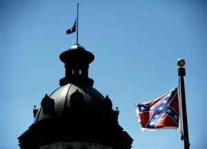 In this June 19, 2015, photo, a Confederate flag flies near the South Carolina Statehouse in Columbia, S.C.  Whether South Carolina should continue to fly the Confederate flag on its statehouse grounds is the latest in a series of issues to arise this summer challenging the GOPs effort to build the young and diverse coalition of voters it likely needs to win the White House.  (AP Photo/Rainier Ehrhardt)