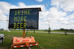 An electronic road sign with the words DRINK MORE BEER is shown on Tuesday, June 23, 2015, in Frankenlust Township, Mich. An auction company has sold the sign for about $600 after it attracted attention from passers-by with its message.  (Yfat Yossifor/The Bay City Times via AP) LOCAL TELEVISION OUT; LOCAL INTERNET