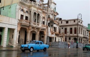Traffic moves beside a building in need of repair, on the Malecon in Old Havana, Cuba, Tuesday, June 2, 2015. In some destinations, tourist areas are located far from the rhythms of everyday life. But visitors who wander through Old Havana or Habana Vieja, as locals call it, cant help but get a sense of how ordinary Cubans live. (AP Photo/Desmond Boylan)