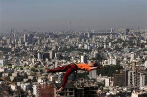 In this picture taken Friday, May 22, 2015, Iranian Hamed Heidari lies across a slackline anchored between two rocks during practice in the mountains overlooking Tehran, Iran.  (AP Photo/Vahid Salemi)
