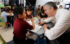 FILE - In this May 14, 2015, file photo, Education Secretary Arne Duncan visits with young student Mario Corona, age 6, in kindergarten at McGlone Elementary School in the Montbello section of Denver. The Obama administration is giving seven more states and the District of Columbia more flexibility from the requirements of the Bush-era No Child Left Behind education law. In addition to Washington, Duncan on June 23 renewed waivers for Georgia, Hawaii, Kansas, Missouri, Nevada, New York, and West Virginia. (AP Photo/Brennan Linsley, File)