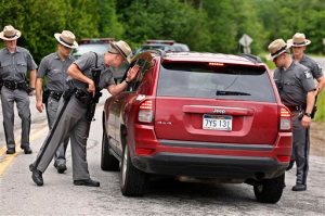New York State Trooper Steven J. Gill searches a vehicle in Malone, N.Y., Tuesday, June 23, 2015, while searching for two prison escapees from Clinton Correctional Facility. Police began focusing intensely on an area 20 miles west of the prison that inmates David Sweat and Richard Matt escaped from prison on June 6. (Jason Hunter/The Watertown Daily Times via AP)  SYRACUSE OUT