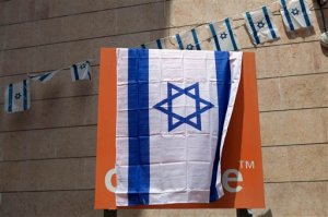 The Orange company logo is seen covered with an Israeli flag at the "Partner Orange" Communications Company's offices in the city of  Rosh Haain, Israel, Thursday, June 4, 2015. An Israeli Cabinet minister has called on the French president to fire the chief executive of French telecom giant Orange. Culture Minister Miri Regev issued her appeal on Thursday, a day after Orange's CEO announced in Cairo that he would like to sever his company's ties to Israel as soon as possible. (AP Photo/Dan Balilty)