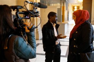 FILE - In this Feb.25, 2015 file photo, plaintiff Bocar, center, is interviewed by the media at the Paris appeals court in Paris, France. A French appeals court has ruled Wednesday June 24, 2015 that police carried out unjustified identity checks on five minority men, ordering the government to pay them damages in an unprecedented ruling that activists hope will help reduce widespread discrimination. (AP Photo/Francois Mori, File)