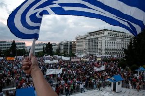 An anti-austerity protester waves a Greek flag during a rally in front of the parliament in Athens, Greece, on Sunday, June 21, 2015. A day ahead of a crucial emergency eurozone summit, European leaders renewed efforts to reach a deal between Greece and its creditors that would allow the debt-ridden country to avoid a default and a potentially disastrous exit from the euro. (AP Photo/Yorgos Karahalis)