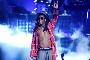 FILE - In this June 29, 2014 file photo, Lil' Wayne performs at the BET Awards at the Nokia Theatre in Los Angeles. Police in suburban Atlanta say a man accused of shooting at rapper Lil Waynes tour bus has surrendered and is being held without bond. Cobb County police spokeswoman Alicia Chilton says Jimmy Carlton Winfrey of Atlanta is being held in connection with the shooting on March 26. County sheriffs records say Winfrey surrendered Tuesday, June 2, 2015. (Photo by Chris Pizzello/Invision/AP, File)