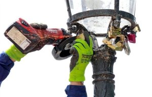 A Paris city employee uses a grinder to cut locks from a street lamp on the famed Pont des Arts bridge in Paris, Monday June 1, 2015. Lovers in Paris, beware: City authorities are taking down thousands of padlocks affixed to the famed Pont des Arts bridge. The city council says the locks, usually hung by couples to express eternal love, cause long-term damage to Paris heritage and sometimes pose a security risk. Last summer a chunk of fencing fell off under their weight. (AP Photo/Remy de la Mauviniere)