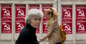 FILE - In this May 28, 2015, file photo, people walk by posters advertising the Party of Communists of Moldova, in Chisinau, Moldova. Moldovans are voting in local elections Sunday, June 14, 2015, which are seen as a test of whether the country is committed to European integration or will move closer to Russia's orbit. (AP Photo/Vadim Ghirda, File)