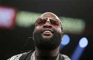 FILE - In this May 3, 2014, file photo, rapper Rick Ross watches the action at the Mayweather-Maidana title boxing fight in Las Vegas. Ross is facing kidnapping and assault charges after a U.S. Marshals Service fugitive task force and deputies arrested him, Wednesday, June 24, 2015, at his mansion outside Atlanta. (AP Photo/Isaac Brekken, File)