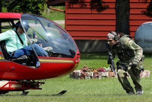 A sheriff's deputy boards a helicopter Monday, June 8, 2015 in rural Eau Claire County, Wis., as law officers search for an armed man who abducted a woman in suburban Milwaukee.  The woman eventually escaped at an Eau Claire convenience store and the perpetrator then led police on a high-speed chase before abandoning his vehicle and fleeing into a wooded area. (Steve Kinderman/The Eau Claire Leader-Telegram via AP)
