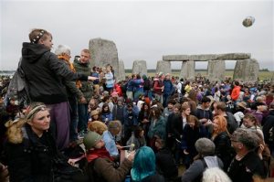People stand on the stones as thousands of revellers gather at the ancient stone circle Stonehenge to celebrate the Summer Solstice, the longest day of the year, near Salisbury, England,Sunday, June 21, 2015. (AP Photo/Tim Ireland)