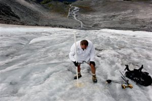 In this Aug. 7, 2015, photo Oliver Grah, a scientist for the Nooksack Indian Tribe, measures ice melt on the Sholes Glacier in Mount Baker, Wash. Glaciers on Mount Baker and other mountains in the North Cascades are thinning and retreating. (AP Photo/Manuel Valdes)