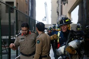 Firefighters go for a rest after putting out a fire at a multistory residential compound known as Radium that accommodates workers for state oil giant Saudi Aramco, in the eastern city of Khobar, Saudi Arabia, Sunday, Aug. 30, 2015. The fire broke out Sunday in the basement of the sprawling residential complex in Saudi Arabia's oil-rich east, killing at least 10 people and injuring more than 200, with some of the injured in critical condition, officials in the kingdom said. (AP Photo)