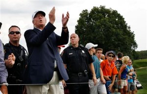 Republican presidential candidate Donald Trump, second left, applauds play as he walks with a crowd during the final round of play at The Barclays golf tournament Sunday, Aug. 30, 2015, in Edison, N.J. (AP Photo/Mel Evans)