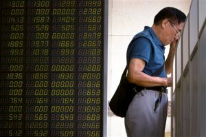 A Chinese investor monitors stock prices on a computer terminal at a brokerage house in Beijing, Tuesday, Aug. 25, 2015.  China's main stock market index has fallen for a fourth day, plunging 7.6 percent to an eight-month low. (AP Photo/Mark Schiefelbein)