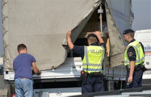 Austrian police officers inspect a truck at the Austrian-Hungarian border in Nickelsdorf, Austria on Monday, Aug. 31, 2015. Austrias decision to start inspecting trucks at its border with Hungary after 71 migrants died in a food truck, created a huge traffic jam on the main Budapest-Vienna highway on Monday. (AP Photo/Hans Punz)