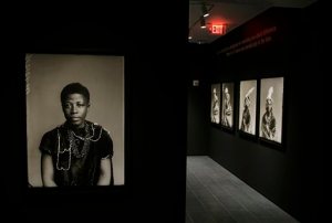 In this Thursday, Aug. 27, 2015, photo, an 1891 portrait of Johanna Jonkers, sitting for a London Stereoscopic Company photographer, hangs with other portraits made in studios across Britain in the 19th and early 20th century, being installed for the show "Black Chronicles II" at the Ethelbert Cooper Gallery of African & African American Art in Cambridge, Mass. The show runs from Wednesday, Sept. 2, through Friday Dec. 11, 2015. (AP Photo/Stephan Savoia)