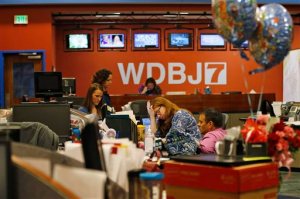 Members of the WDBJ-TV7 news staff prepare for the early morning newscast at the station, Thursday, Aug. 27, 2015, in Roanoke, Va. Reporter Alison Parker and cameraman Adam Ward were killed by a former colleague during a live broadcast Wednesday, while on assignment in Moneta. The balloons and flowers, at right, are addressed to Ward's fiancee, Melissa Ott, who was celebrating her last day at WDBJ on Wednesday, before moving to a station in North Carolina. (AP Photo/Steve Helber)