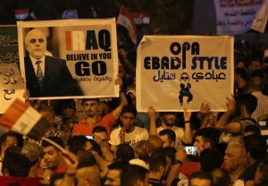 Demonstrators chant pro-Iraqi Prime Minister Haider al-Abadi, in the poster left, during a demonstration at Tahrir Square in Baghdad, Iraq, Friday, Aug. 14, 2015. Thousands of people demonstrated in cities across Iraq on Friday to show support for a reform plan put forth by the prime minister this week while still demanding that greater measures be taken to target corruption and restore basic services. (AP Photo/Khalid Mohammed)
