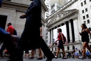 In this Monday, Aug. 24, 2015, photo, pedestrians walk past the New York Stock Exchange. Global stocks mostly fell on Monday, Aug. 31, 2015, after a U.S. Federal Reserve official suggested a September interest rate hike still was possible and weak Japanese factory activity provided more evidence of a sluggish global economy. (AP Photo/Seth Wenig)