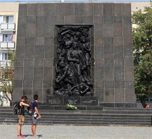 In this Aug 12, 2015 picture two tourists visit the monument to the Jews who fought and died in the Warsaw Ghetto Uprising of 1943 in Warsaw, Poland. A Polish-American Holocaust survivor, Sigmund Rolat, plans to build a memorial to the thousands of Polish gentiles who rescued Jews during the war on a square near this memorial and next to a major new Jewish history museum. (AP Photo/Czarek Sokolowski)