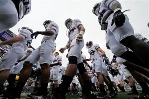 FILE - In this Oct 6, 2012 file photo, the Northwestern football team heads to the locker room after warming up before an NCAA college football game against Penn State in State College, Pa. The National Labor Relations Board has dismissed a historic ruling that Northwestern University football players are school employees who are entitled to form what would be the nation's first union of college athletes. (AP Photo/Gene J. Puskar, File)