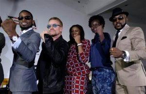 Irish rock star Bono, second left, poses with African music stars after a press conference in Lagos, Nigeria, Friday, Aug. 28, 2015, African stars and rock star Bono say music can help push for the empowerment of women globally. Bono and the top African male musicians D'banj, Diamond and Banky W announced Friday that they will be included in a remix of the song "Strong Girl" - a rallying cry for women's empowerment which features top African female talent. (AP Photo/Sunday Alamba)