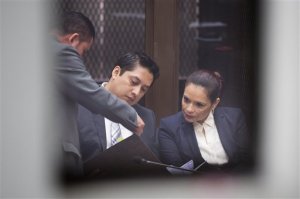 Guatemala's former Vice President Roxana Baldetti, right, talks with her lawyer Mario Cano as she waits for her hearing inside a courtroom, photographed through a window in Guatemala City, Monday, Aug. 24, 2015. Baldetti was detained Friday in connection with a customs corruption scandal that previously led to her resignation. Prosecutors are also seeking to investigate President Otto Perez Molina. (AP Photo/Moises Castillo)