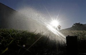 FILE - In this June 23, 2015, file photo a lawn is irrigated in Sacramento, Calif. A report is due out Thursday, Aug. 27, 2015 on monthly state water conservation figures. Many California cities are conserving well, and officials are turning their attention to the few cities/agencies that arent doing so well. (AP Photo/Rich Pedroncelli, File)