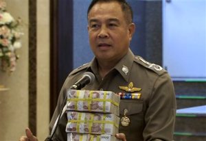 In this image taken from video, National police chief Somyot Poompanmoung holds a cash reward at a press conference in Bangkok, Thailand, Monday, Aug. 31, 2015. Thai police have awarded themselves a 3 million baht ($84,000) reward offered to the public for tips leading to the arrest of suspects in Bangkoks deadly bombing after a man was arrested over the weekend in an apartment where police found bomb-making equipment. (AP Photo/AP Video)