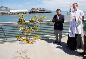 FILE - In this July 6, 2015 file photo, Father Cameron Faller, right, and Julio Escobar, of Restorative Justice Ministry, conduct a vigil for Kathryn Steinle on Pier 14 in San Francisco. A San Francisco judge is set to hear evidence in a shooting at a city pier that became a flash point in the national immigration debate because the suspect was released from jail despite a request from federal immigration authorities to keep him locked up. Juan Francisco Lopez Sanchez is due in court on Tuesday, Aug. 25, 2015, for a preliminary hearing to determine whether there is enough evidence to try him on a murder charge in the July slaying of 32-year-old Kathryn Steinle. Sanchez has pleaded not guilty. (AP Photo/Beck Diefenbach, File)