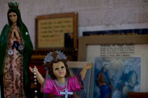 In this June 17, 2015 photo, religious figures adorn the home of Yolanda Alvarez Antunez, in Ahuehuepan, Mexico. She still struggles to makes sense of a world in which good people routinely are abducted, where one victim survives and another does not. But there is no sense in this random violence, no victory in having made it home from her own kidnapping to suffer the eternal pain of her husbands. So Yolanda turns to her faith.  (AP Photo/Dario Lopez-Mills)