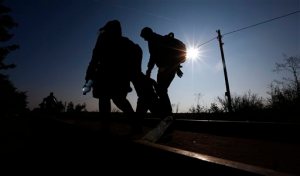 A migrant family walk to the border line between Serbia and Hungary near Roszke, southern Hungary, Sunday, Sept. 13, 2015. Hundreds of thousands of Syrian refugees and others are still making their way slowly across Europe, seeking shelter where they can, taking a bus or a train where one is available, walking where it isn't. The latest string of walkers made their way Friday from the Hungarian border across Austria toward the capital, Vienna. (AP Photo/Matthias Schrader)