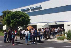 FILE - In this April 28, 2015 file photo, students wait outside Everest College in Industry, Calif., hoping to get their transcriptions and information on loan forgiveness and transferring credits to other schools. Almost 12,000 students are asking the federal government to discharge their college loan debt, asserting that their school either closed or lied to them about job prospects, according to government data released Thursday. The figure represents an unprecedented spike in what's called a "borrower's defense" claim following the collapse of Corinthian Colleges, a for-profit college chain that had become a symbol of fraud in the world of higher education. Under higher education law, students who believe they were victims of fraud can apply to have their loans discharged. (AP Photo/Christine Armario)
