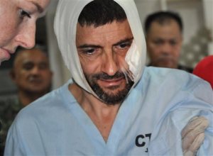 FILE - In this  Dec. 6, 2014 file photo, Swiss hostage Lorenzo Vinciguerra, is treated in a hospital following his daring escape from the hands of the Muslim Abu Sayyaf extremists, in Jolo in southern Philippines. Vinciguerra, who has been a hostage for two years, made a dramatic escape on Dec. 6, 2014, from Abu Sayyaf extremists when he hacked a rebel commander then got shot as he dashed to freedom amid a military artillery assault.  The recent abductions of three Westerners and a Filipino woman from a southern Philippine resort are the latest reminder of the long-running security problems that have hounded a region with bountiful resources and promises, but hamstrung by stark poverty and an array of insurgents and outlaws.(AP Photo/Nickee Butlangan, File)