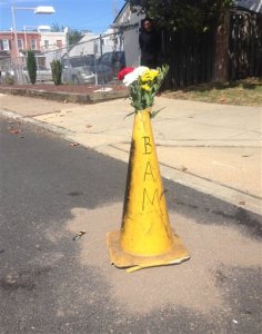 Flowers lie at the scene of where Delaware police officers fatally shot an armed man Wednesday, Sept. 23, 2015, in wheelchair after responding to a call that he had a self-inflicted gunshot wound, is seen Thursday, Sept. 24, 2015, in Wilmington, Del. Authorities say a shooting occurred and the man died at the scene.(AP Photo/Randall Chase)