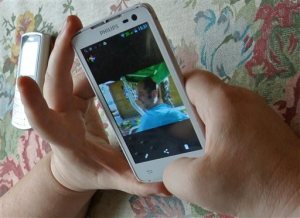 In this Friday, Sept. 4, 2015 photo Alla Kravtsova looks at a photo of her husband, Gennady Kravtsov, as she sits at her home in northern Moscow. Kravtsova's husband, a former intelligence employee Gennady Kravtsov, is on trial on treason charges for sending a cover letter to Sweden. The Russian government increasingly has portrayed any cooperation with foreign companies or nationals as a potential security threat, a throwback to Soviet times when any contact with foreigners aroused suspicion. (AP Photo/Nataliya Vasilyeva)