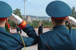 Russian President Vladimir Putin, background, stands during a minute of silence as he takes part in a wreath laying ceremony on Wednesday, Sept. 2, 2015 in Chita, Russia, during a short stop on his way to China. Russian President Vladimir Putin laid wreath at war memorial in Far Eastern forces command HQ, to mark the end of World War II in the Far East. (Mikhail Klimentyev/RIA-Novosti, Kremlin Pool Photo via AP)