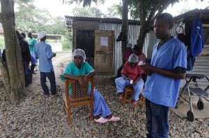 In this Monday, Aug. 10, 2015 photo, Maxon Kobba, right, a nurse who works at the government hospital in Kenema, eastern Sierra Leone stands next to colleagues at the facility. Kobba says as many as 20 Ebola patients could die in one night at the facility. An Associated Press investigation has found that the World Health Organization and other responders faced key obstacles in their efforts to stop the spiraling Ebola outbreak in the summer of 2014 in Kenema, a pivotal seeding point for the virus and a microcosm of the messy response across West Africa. (AP Photo/Sunday Alamba)