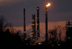 FILE - In this Feb. 13, 2015, file photo, stacks and burn-off from the Exxon Mobil refinery are seen at dusk in St. Bernard Parish, La. A barrel of U.S. crude fell below $40 per barrel, Friday, Aug. 21, 2015, for the first time since the end of the global economic crisis. (AP Photo/Gerald Herbert, File)