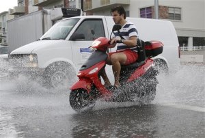 FILE - In this Sept. 23. 2014 file photo, a motorcyclist negotiates heavily flooded streets as rain falls in Miami Beach, Fla.  Expect nuisance flooding to increase along some of the nations coasts during the next several months, federal scientists predict.  A combination of sea level rise from human caused global warming and the giant El Nino will likely combine to increase the type of minor street flooding that doesnt cause big damage, but lots of inconvenience, according to the National Oceanic and Atmospheric Administration.  (AP Photo/Lynne Sladky)