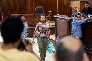 Egyptian Al-Jazeera English journalist Baher Mohammed, center, carries a plastic bag of clothes before his verdict in a makeshift courtroom in Tora prison in Cairo, Egypt, Saturday, Aug. 29, 2015. An Egyptian court on Saturday sentenced three Al-Jazeera English journalists to three years in prison, the last twist in a long-running trial criticized worldwide by press freedom advocates and human rights activists. (AP Photo/Amr Nabil)
