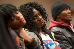 FILE - In this April 27, 2015, file photo, family members of Freddie Gray, sister Fredricka Gray, left, mother Gloria Darden, center, and stepfather Richard Shipley listen during a news conference after a day of unrest following the funeral of Freddie Gray in Baltimore. Gray's parents reached a tentative $6.4 million settlement with the city of Baltimore. The deal, announced Tuesday, Sept. 8, 2015, appeared to be among the largest settlements in police death cases in recent years and happened just days before a judge is set to decide whether to move a trial for six officers charged in Gray's death. (AP Photo/Evan Vucci, File)