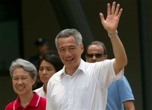 Singapore's Prime Minister Lee Hsien Loong waves as he and his wife Ho Ching leave after voting at a polling station in Singapore, Friday, Sept. 11, 2015. Singaporeans began voting Friday in general elections whose results hold no surprises - the ruling People's Action Party will extend its 50-year-rule by another five years. But what will be closely watched is the percentage of votes it garners, which will determine the measure of its popularity as the city-state goes through tough economic times. (AP Photo/Ng Han Guan)