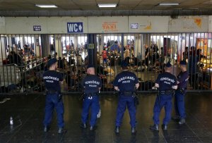 Hungarian policemen guard an entrance to the Keleti Railway Station in Budapest, Hungary, Wednesday, Sept. 2, 2015, as hundreds of migrants demanded to be let on trains to Germany. Over 150,000 migrants have reached Hungary this year, most coming through the southern border with Serbia. Many apply for asylum but quickly try to leave for richer EU countries. (AP Photo/Petr David Josek)