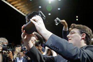FILE - In this June 11, 2015 file photo, Oculus founder Palmer Luckey holds up the new Oculus Rift virtual reality headset for photographers following a news conference, in San Francisco. While more than 1,500 attendees are expected on Saturday, Aug. 29, 2015, at the VRLA expo, the event probably wont feel very crowded. Thats because headset-wearing convention goers will be transported to other worlds during the second-annual celebration of virtual reality at the Los Angeles Convention Center. (AP Photo/Eric Risberg, File)